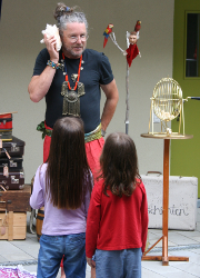 Erzähler mit Schirm auf Riesenstuhl